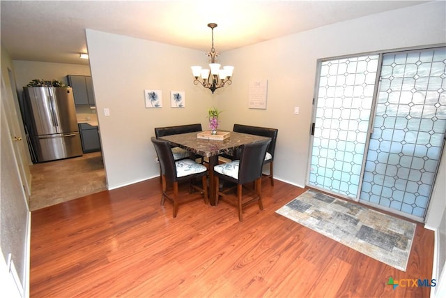 dining space featuring wood finished floors and a chandelier