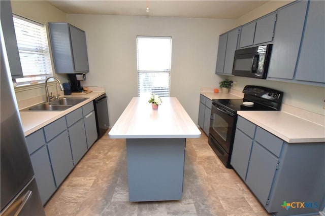 kitchen with light countertops, a kitchen island, a sink, and black appliances