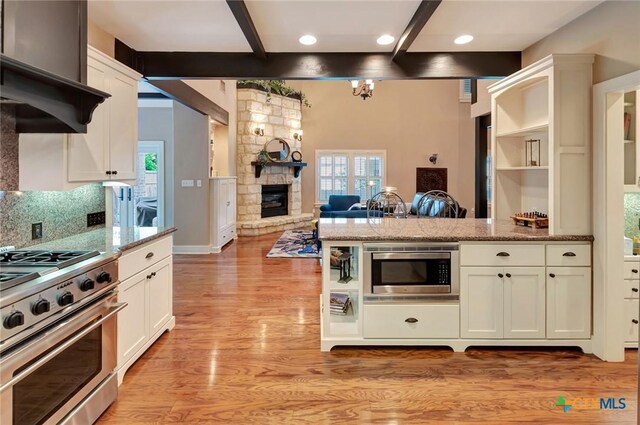 6 Cotswold Ln, Victoria, TX 77904 - kitchen with stainless steel appliances, beamed ceiling, light wood-type flooring, open floor plan, and white cabinets