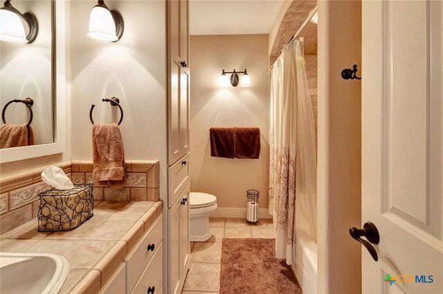 6 Cotswold Ln, Victoria, TX 77904 - full bath with double vanity, tile patterned flooring, toilet, and shower / tub combo with curtain