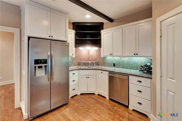 6 Cotswold Ln, Victoria, TX 77904 - kitchen with appliances with stainless steel finishes, a sink, light wood-style flooring, white cabinets, and decorative backsplash