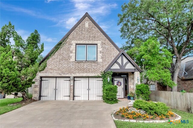 6 Cotswold Ln, Victoria, TX 77904 - english style home featuring brick siding, a garage, and concrete driveway