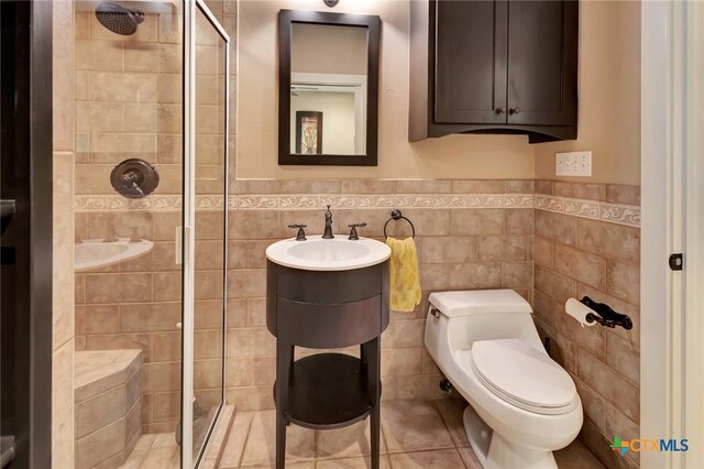 6 Cotswold Ln, Victoria, TX 77904 - full bathroom with tile walls, a shower stall, toilet, wainscoting, and a sink