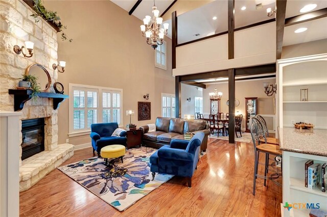 6 Cotswold Ln, Victoria, TX 77904 - living room with a chandelier, wood finished floors, a high ceiling, a stone fireplace, and baseboards