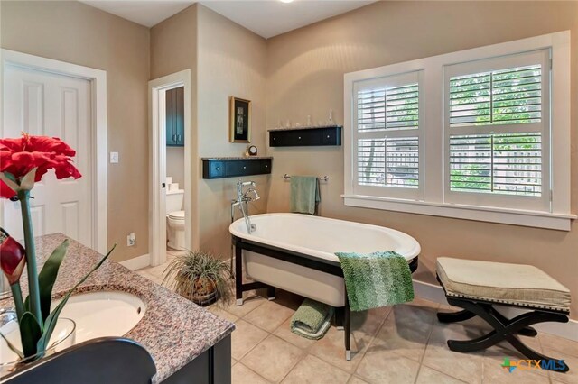 6 Cotswold Ln, Victoria, TX 77904 - bathroom with a freestanding tub, vanity, tile patterned flooring, toilet, and baseboards