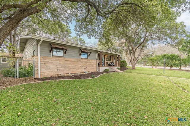 ranch-style home featuring a porch and a front lawn