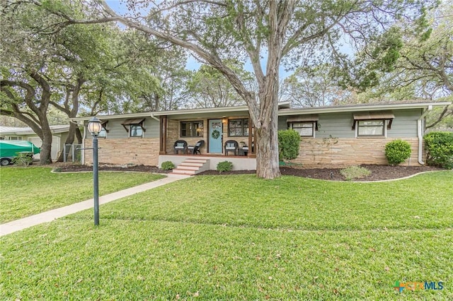 ranch-style home with a front yard and covered porch