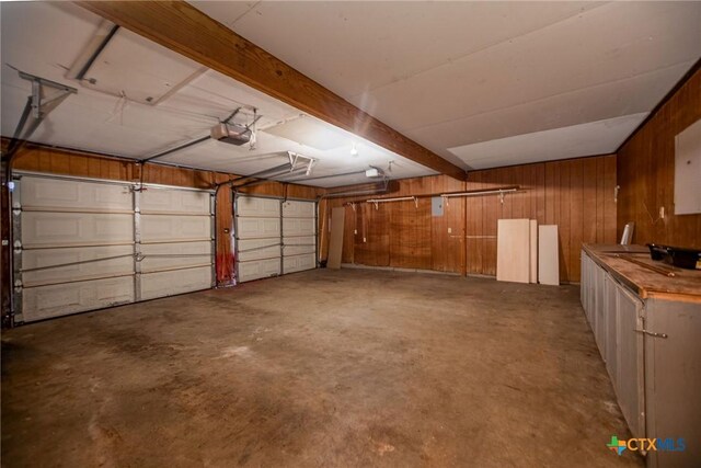 garage with wooden walls and a garage door opener