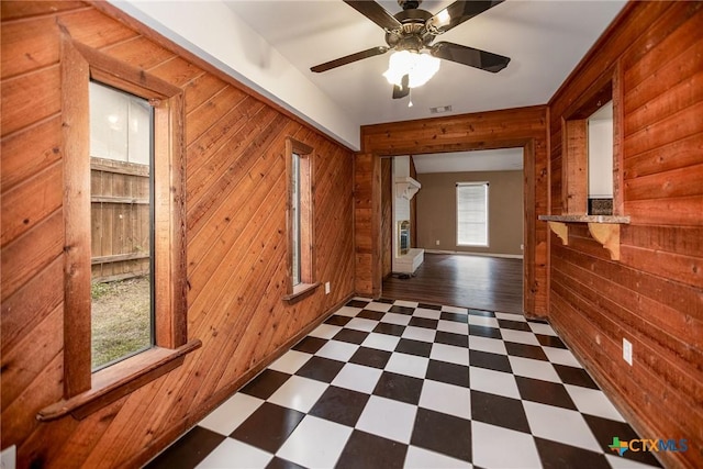 spare room featuring visible vents, dark floors, and wood walls