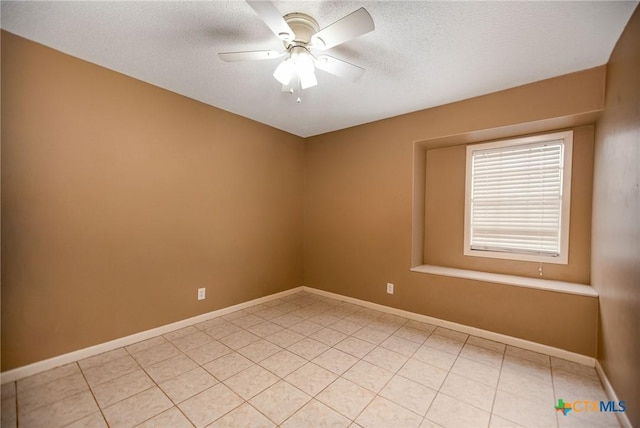 empty room featuring baseboards, a ceiling fan, a textured ceiling, and light tile patterned floors