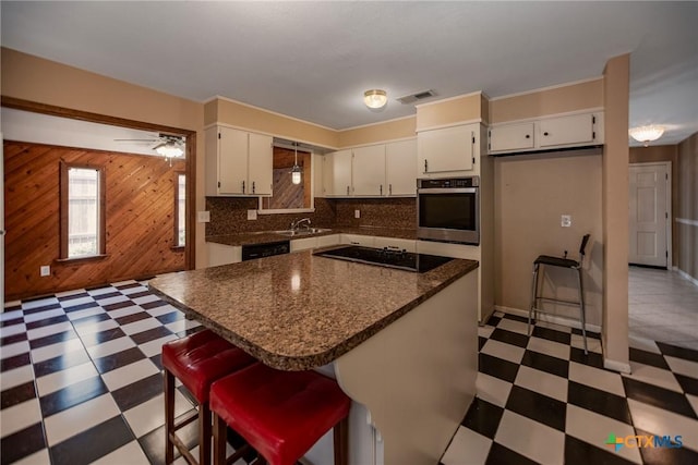 kitchen with visible vents, black appliances, a sink, and light floors