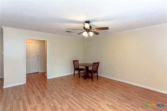 dining area with ceiling fan, light wood-type flooring, crown molding, and a textured ceiling