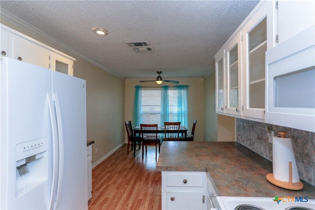 kitchen with ceiling fan, white appliances, white cabinets, a textured ceiling, and light hardwood / wood-style flooring