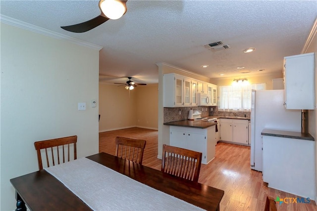 dining room featuring ceiling fan, ornamental molding, light hardwood / wood-style flooring, and sink