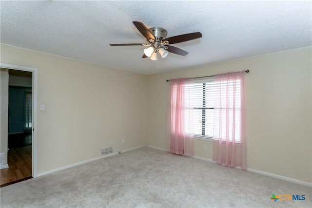 unfurnished room featuring ceiling fan, light colored carpet, and a textured ceiling