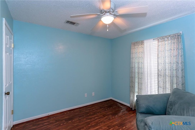 unfurnished room with a textured ceiling, ceiling fan, and dark hardwood / wood-style floors