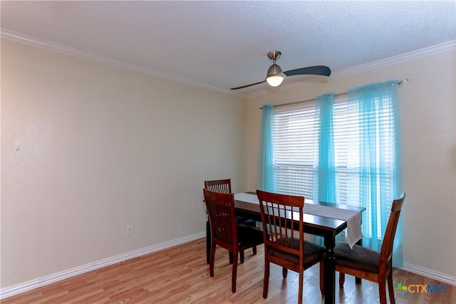 dining area with ceiling fan, a textured ceiling, ornamental molding, and light hardwood / wood-style floors