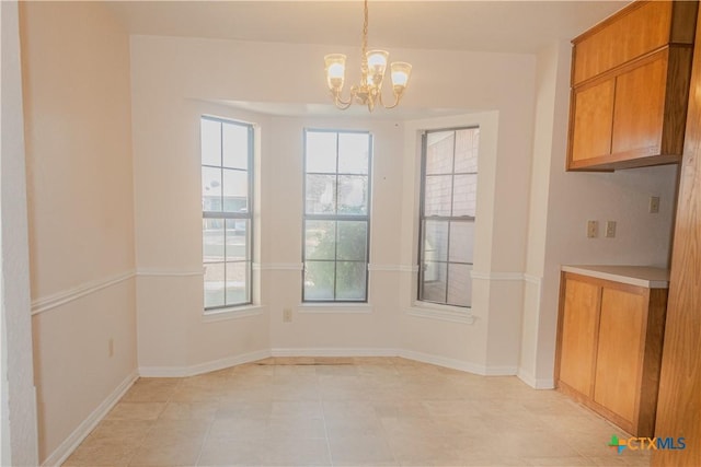 unfurnished dining area featuring a notable chandelier