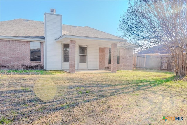 rear view of property with a yard and a patio