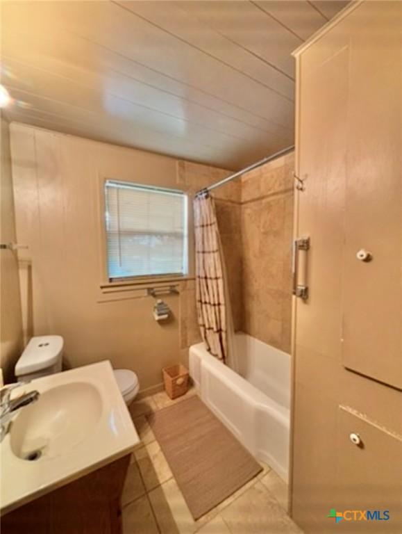 full bathroom with shower / tub combo, vanity, tile patterned floors, and toilet