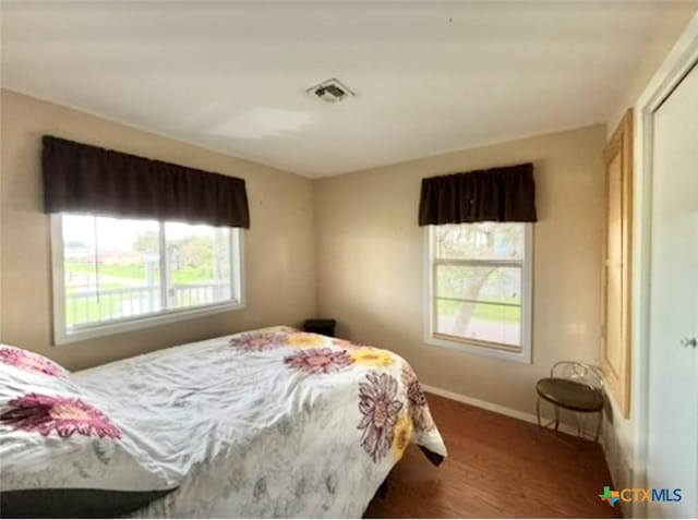 bedroom with dark hardwood / wood-style floors