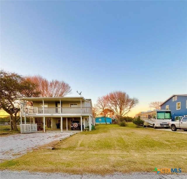 view of front of house with a carport and a yard