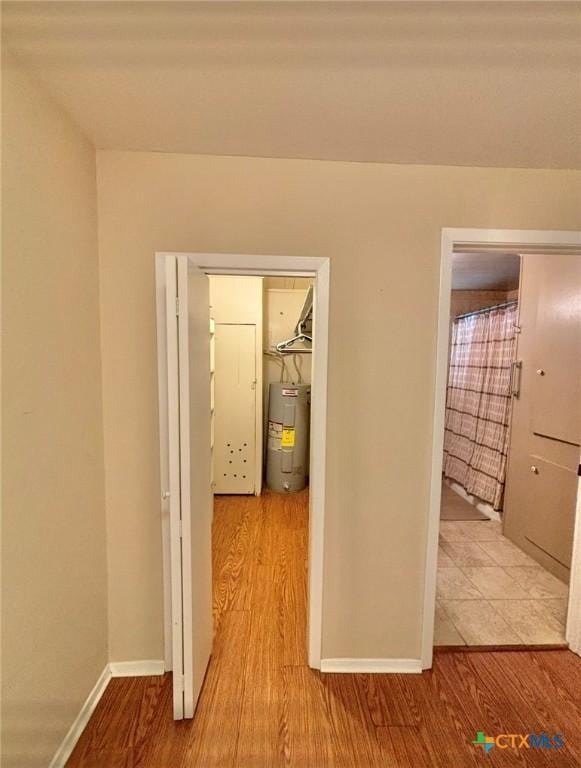 corridor featuring light hardwood / wood-style floors and electric water heater