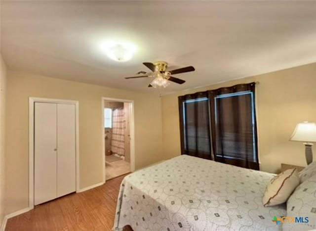 bedroom with ensuite bathroom, ceiling fan, and light wood-type flooring