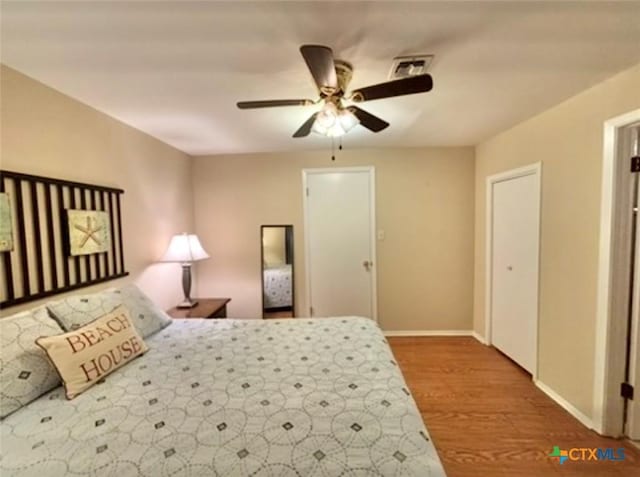 bedroom with hardwood / wood-style floors and ceiling fan