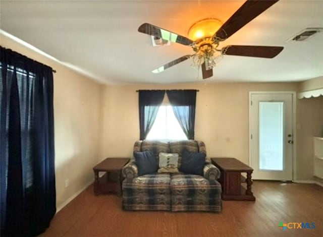 living area with wood-type flooring and ceiling fan