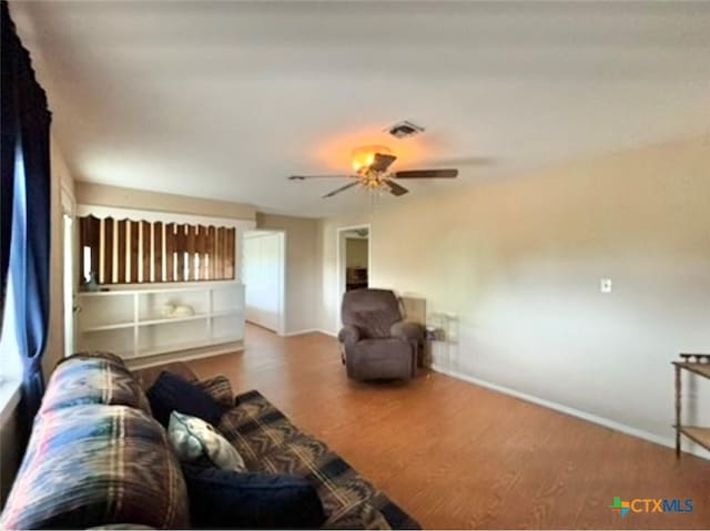 living room with wood-type flooring and ceiling fan