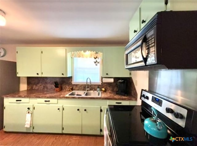 kitchen with white cabinetry, sink, decorative backsplash, stainless steel range with electric stovetop, and light wood-type flooring