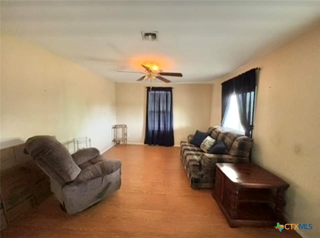 living room featuring light hardwood / wood-style flooring and ceiling fan