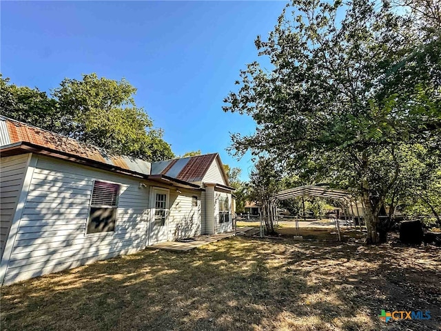 view of home's exterior featuring a yard and a carport