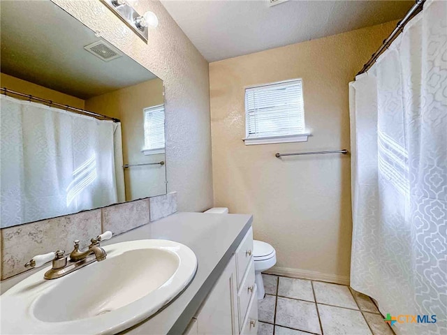 bathroom with toilet, vanity, a textured ceiling, and tile patterned floors