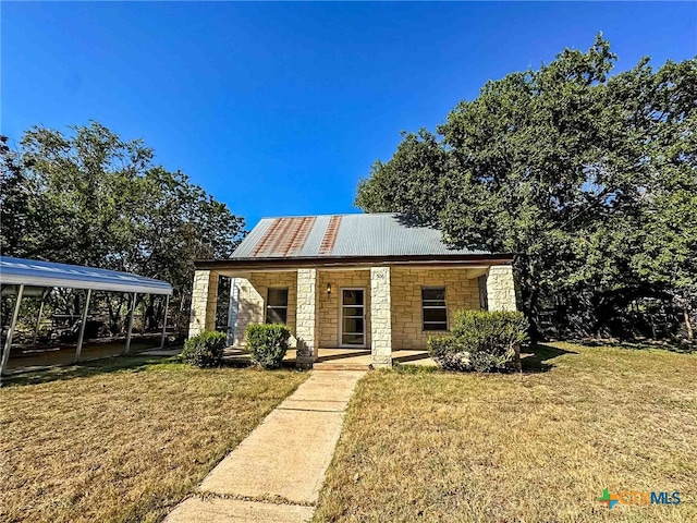 bungalow-style house featuring a porch, a carport, and a front lawn