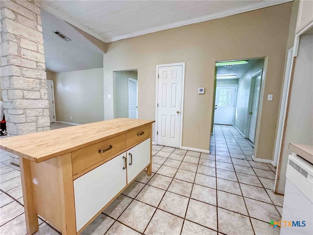 kitchen featuring white cabinetry, butcher block countertops, light tile patterned flooring, and a kitchen island