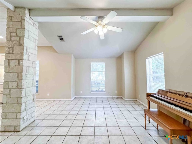 tiled spare room with a wealth of natural light, vaulted ceiling with beams, ceiling fan, and decorative columns