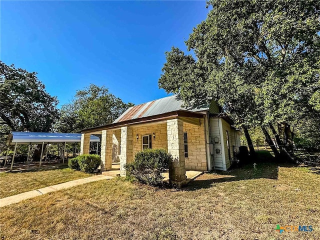 bungalow-style home with a front yard and a carport