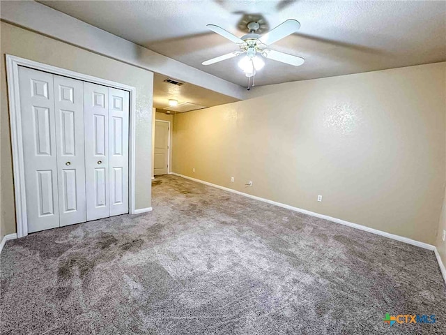 unfurnished bedroom featuring a closet, carpet, a textured ceiling, and ceiling fan