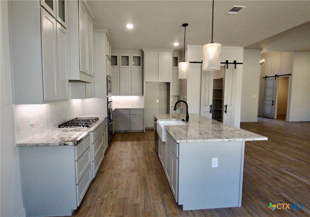 kitchen featuring a barn door, a large island, white cabinets, and hardwood / wood-style flooring