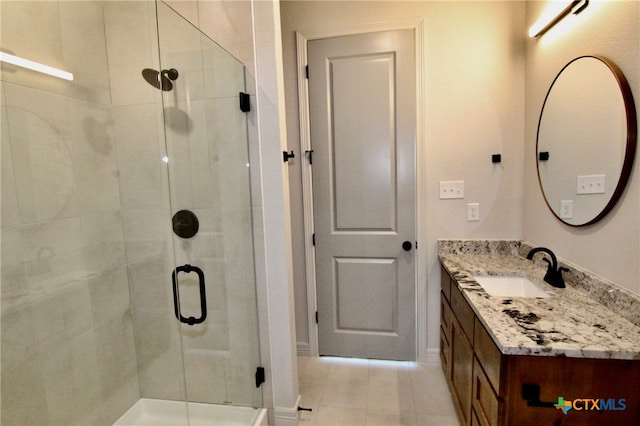 bathroom with tile patterned flooring, vanity, and walk in shower