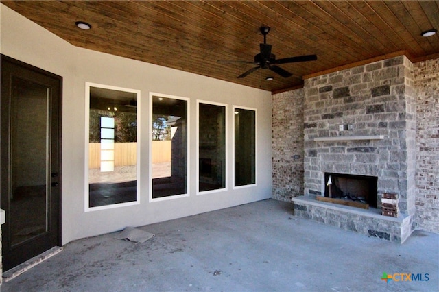 view of patio with an outdoor stone fireplace and ceiling fan