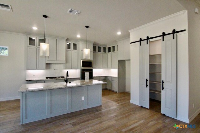 5715 Sparrow Ct, Temple, TX 76502 - kitchen featuring oven, stainless steel microwave, baseboards, recessed lighting, and a barn door