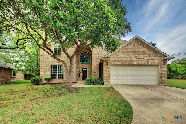 traditional home with a garage, driveway, brick siding, and a front yard