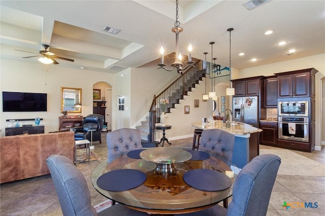 1919 Los Santos Dr, San Marcos, TX 78666 - dining room featuring ceiling fan with notable chandelier, light tile patterned floors, arched walkways, recessed lighting, and stairway
