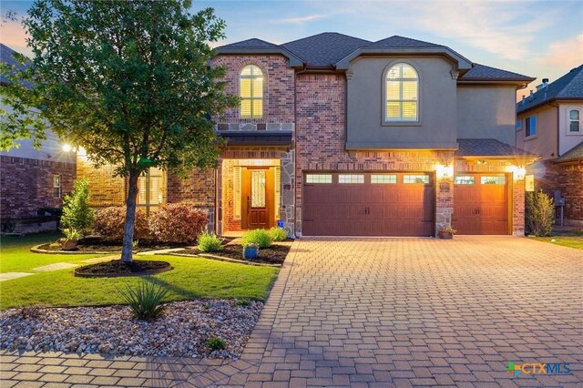 1919 Los Santos Dr, San Marcos, TX 78666 - view of front of house with brick siding, a yard, a garage, and decorative driveway