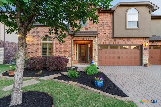 1919 Los Santos Dr, San Marcos, TX 78666 - view of front facade featuring a garage, brick siding, stucco siding, and decorative driveway