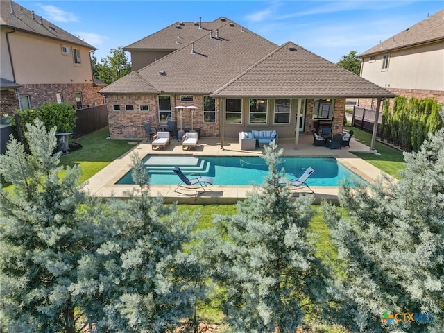 1919 Los Santos Dr, San Marcos, TX 78666 - back of property with brick siding, a fenced backyard, outdoor lounge area, and a patio area