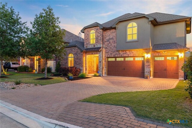 1919 Los Santos Dr, San Marcos, TX 78666 - french country inspired facade with an attached garage, brick siding, a front yard, and decorative driveway